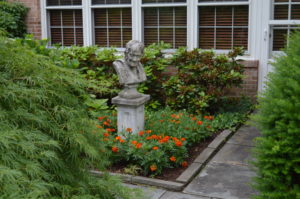 Stone bust in a garden full of orange flowers