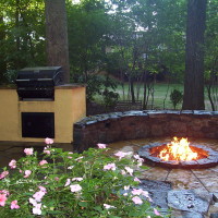 stone firepit and outdoor grill on a patio