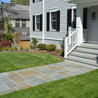 paver walkway up to the front of a residential home with freshly cut grass
