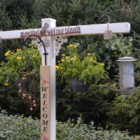 Welcome sign with a hanging bird feeder