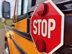 stop sign on the side of a school bus