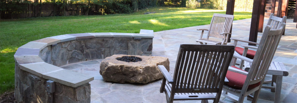 landscape maintenance on a stone fire pit with patio furniture