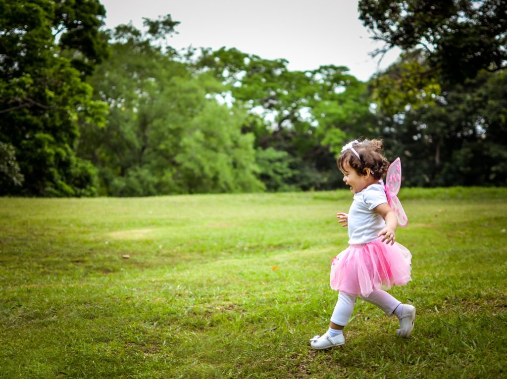 Small child in ballerina costume playing in the grass