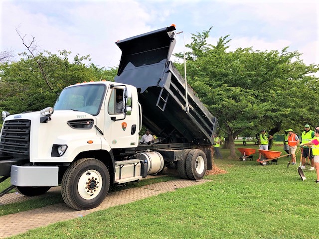 a large truck dumping mulch for the allentuck landscaping team