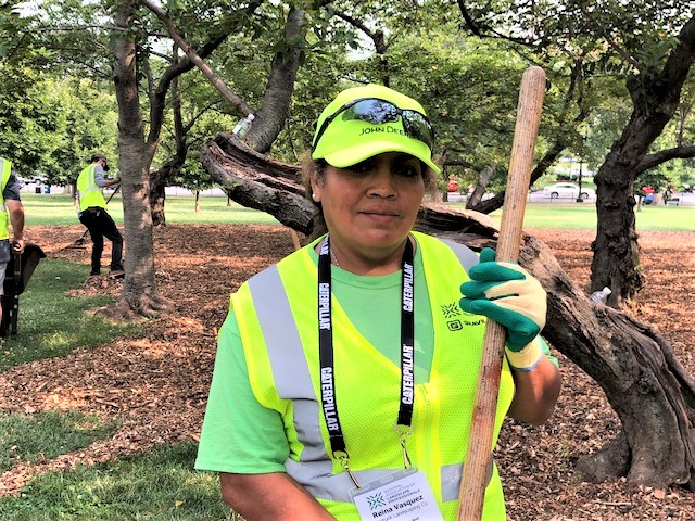 allentuck landscaping team member posing for a photo while mulching