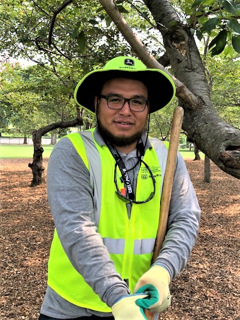 allentuck landscaping team member posing for a photo while mulching