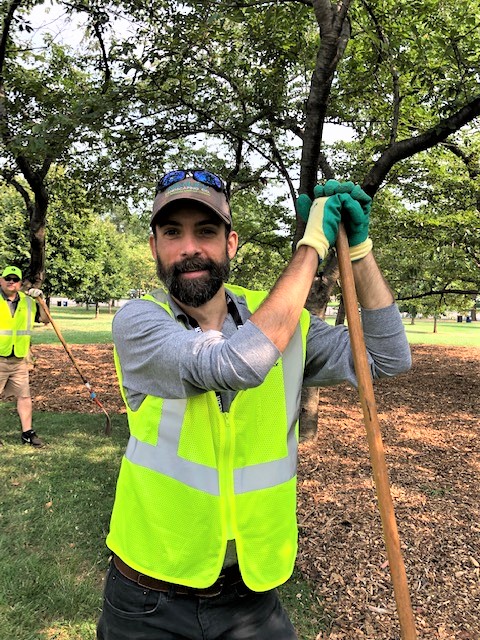 allentuck landscaping team member posing for a photo while mulching