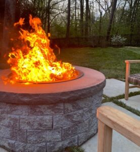 A beautiful outdoor fire pit on a concrete patio.