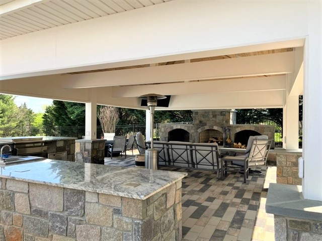Outdoor covered kitchen with stone fireplace