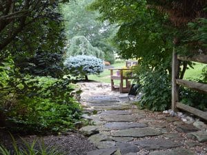 Landscaping design with a water feature and fence along a path
