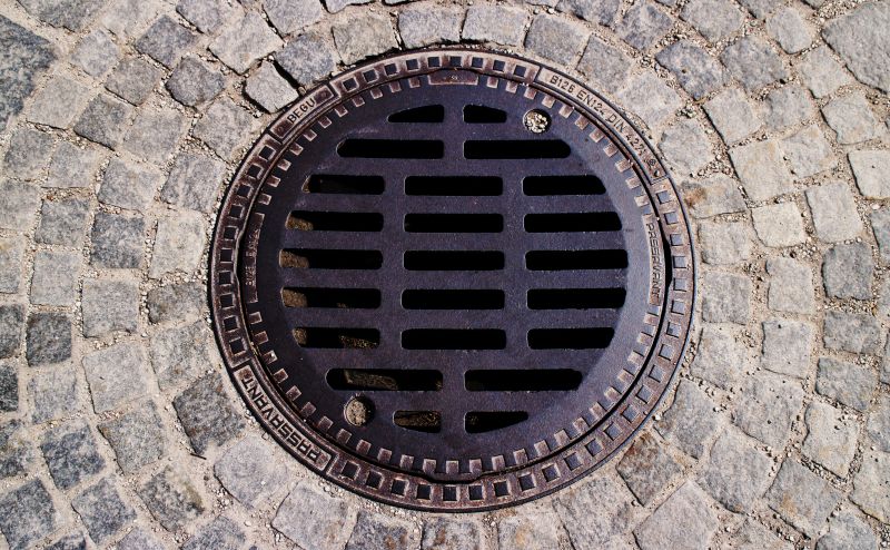 a drainage grate in the middle of a stone patio